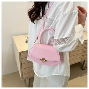 Détail du sac bandoulière rose avec fermoir doré en éventail et bandoulière ajustable