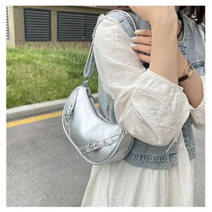 Detail of silver metallic hobo bag with vintage texture and stylish buckle straps