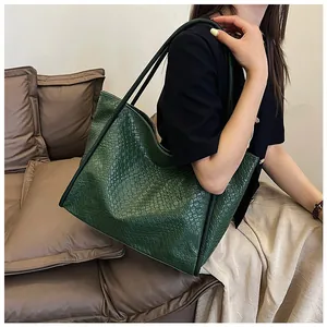 Close-up of deep green woven tote bag texture and thin shoulder straps for daily use