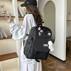 Détail du sac à dos noir avec broderie spatiale et charmant petit ours en peluche