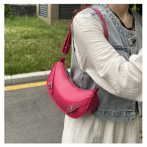 Outdoor street shot of a hot pink saddle bag with silver buckles and eyelet details