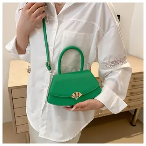 Vue détaillée du sac carré en cuir vert vif avec une boucle métallique dorée en forme d'éventail
