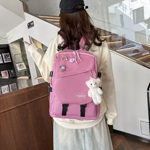 Sac à dos en toile rose avec badges décoratifs et breloque ours en peluche en extérieur