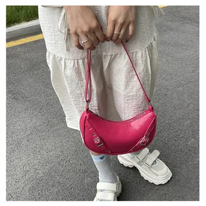 Detail of pink saddle bag with silver buckles and Y2K aesthetic in an outdoor street setting
