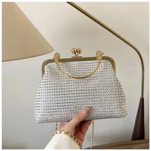 Detail of elegant rhinestone evening bag with gold kiss-lock closure and metal handle
