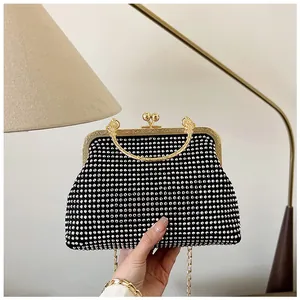 Detailed view of black rhinestone evening clutch with engraved gold metal frame and clasp