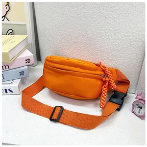Détail du sac de poitrine orange pour enfants avec fermeture éclair tressée et boucle
