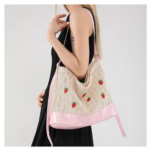 Straw shoulder bucket bag with strawberry embroidery and pink faux leather straps