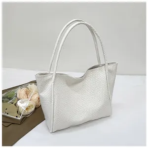 Close-up of white woven leather texture on the large minimalist tote bag with long straps