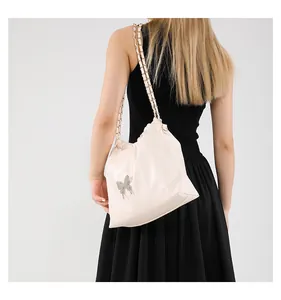 Détail du sac seau en similicuir avec boucle papillon argentée et bandoulière chaîne