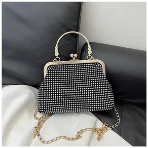Detail of evening bag with silver rhinestones, gold floral handle and ball kiss-lock