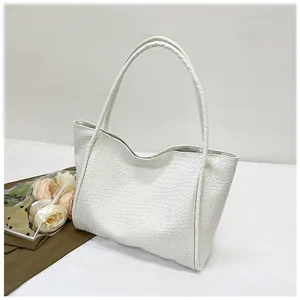 Detailed view of woven texture and slender shoulder straps on this white tote bag