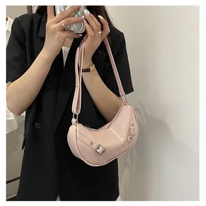Pink hobo saddle bag shown styled on shoulder with black blazer for a modern fashion look