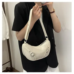 Detail of off-white crescent hobo bag with silver buckle straps and top zipper closure