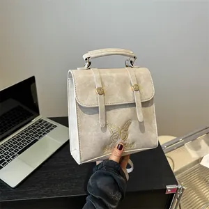 Beige faux leather backpack with gold butterfly embroidery and Fancy Club logo detail