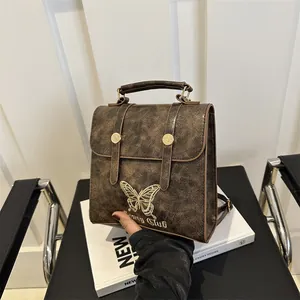 Vintage brown leather backpack with gold butterfly embroidery and top handle