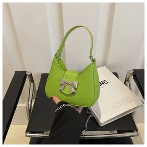 Gros plan d'un sac à main vert fluo en cuir avec boucle en nœud argenté