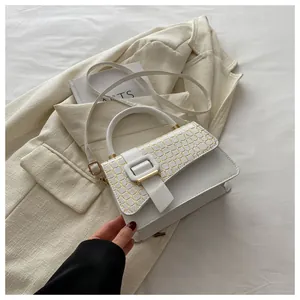 Detailed shot of white leather bag with crocodile texture and gold square buckle