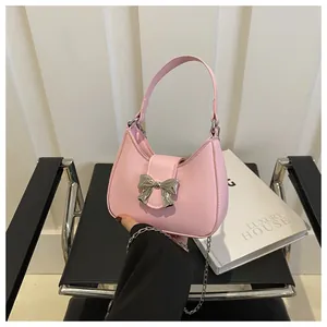 Vue détaillée du sac hobo rose avec boucle nœud argentée et bandoulière en chaîne