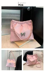 Detail of pink PU leather bucket bag featuring cloud pleats and silver butterfly charm