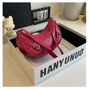 Macro detail of magenta glossy saddle bag with silver buckles and patent leather texture