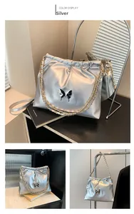 Detailed view of silver metallic pleated bucket bag with butterfly decor and chain strap