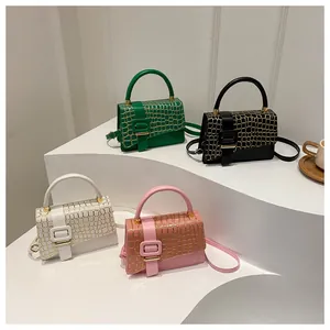 Detail of crocodile embossed square bags in green black white and pink on white display