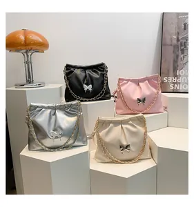 Detail of soft PU bucket bag with pleated design, metal butterfly buckle and chain strap
