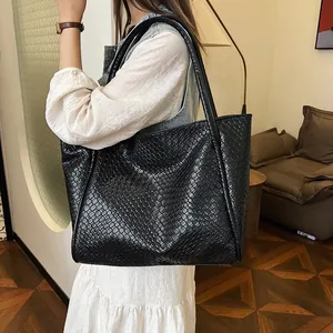 Large black woven tote bag made of premium PU leather with minimalist shoulder straps