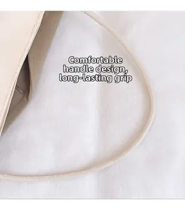 Close-up of comfortable cylindrical handle with stitching on a beige nylon tote bag