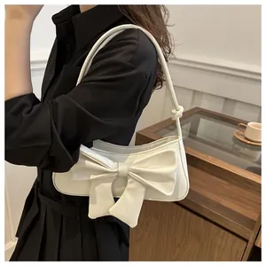 Detalle del lazo grande 3D y textura de patrón de cocodrilo en bolso de hombro blanco