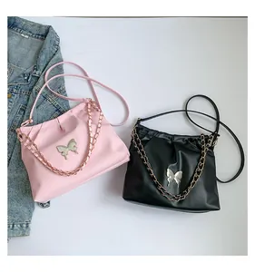 Détail du sac seau en similicuir avec breloque papillon argentée et chaîne