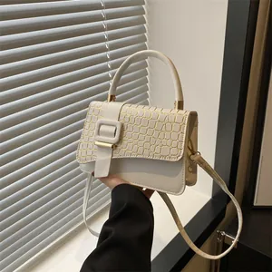 White leather shoulder bag with gold crocodile texture flap and square buckle detail