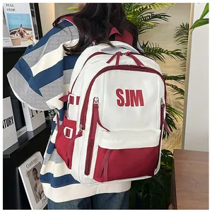 Detail des Kontrast-Rucksacks in Weiß und Burgund mit SJM-Buchstabendruck