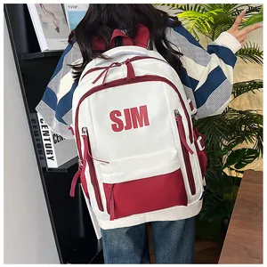 Rückansicht eines rot-weißen Rucksacks mit Buchstabendruck in gemütlicher Wohnatmosphäre