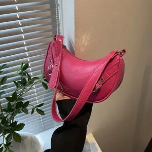 Vibrant hot pink saddle bag in glossy faux leather with adjustable shoulder strap