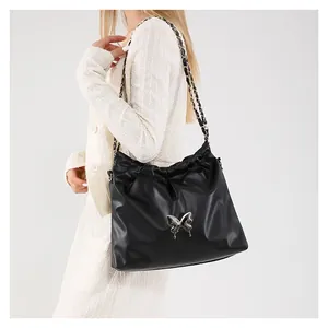 Sac seau souple en similicuir noir avec nœud papillon argenté et bandoulière