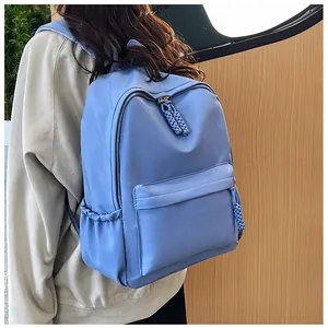 Détail du sac à dos bleu en nylon avec poche latérale pour bouteille et tirette de zip tissée