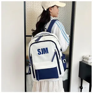 Seitenansicht eines Schülers mit einem weiß-blauen Rucksack mit Buchstaben-Aufdruck
