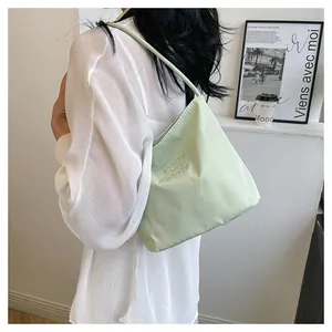 Close-up of light green nylon shoulder bag with Pretty and Liberty embroidery detail