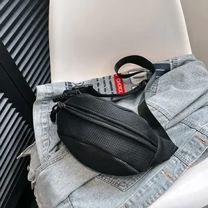 Detail of black mesh waist bag with adjustable strap placed on denim jacket