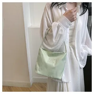 Detail of mint green nylon tote with pretty and liberty embroidery on soft fabric