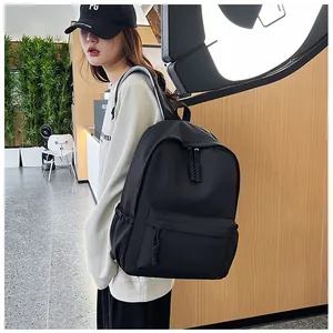 Détail du sac à dos noir en nylon avec poches latérales et fermetures éclair décoratives