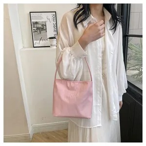 Close-up of pink nylon shoulder bag featuring fine embroidery and soft texture