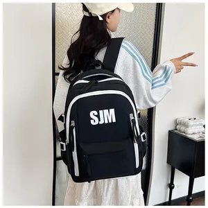 Seitenansicht des schwarzen Nylon-Rucksacks mit weißem SJM-Logo und Verstellgurten