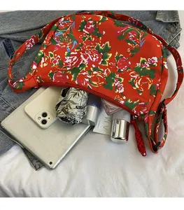 Dettaglio della capiente borsa in nylon con motivo floreale rosso tradizionale e zip