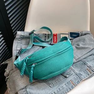 Detail of the teal mesh crossbody bag featuring breathable fabric and adjustable strap