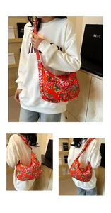 Dettaglio borsa a spalla in nylon rosso con motivi di fiori di peonia e forma a mezzaluna
