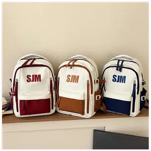 Drei moderne SJM Schulrucksäcke in Rot, Braun und Navy mit Kontrastfarben im Detail