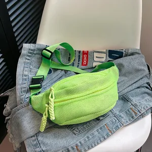 Detail of neon green mesh crossbody bag with durable buckle and woven zipper puller